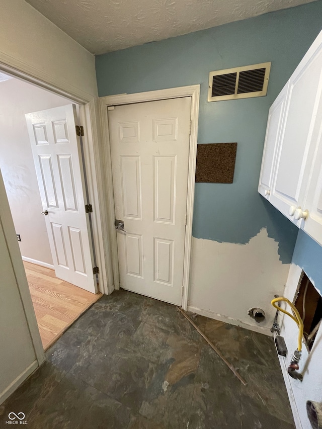 clothes washing area featuring dark hardwood / wood-style floors and a textured ceiling