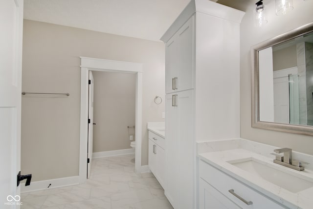 bathroom with walk in shower, vanity, and toilet