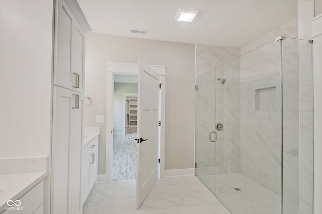 bathroom featuring a textured ceiling, vanity, and a shower with door