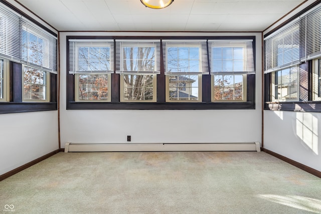 unfurnished room with light carpet, crown molding, and a baseboard heating unit