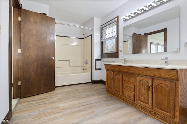 bathroom featuring hardwood / wood-style floors, vanity, and  shower combination