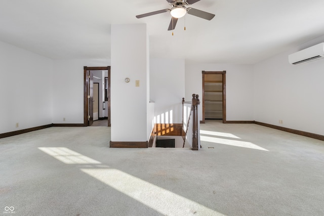 carpeted spare room with ceiling fan and an AC wall unit