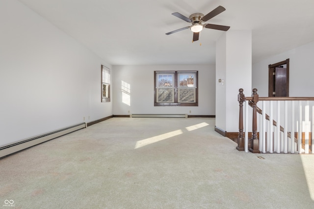 unfurnished room with light colored carpet, baseboard heating, and ceiling fan