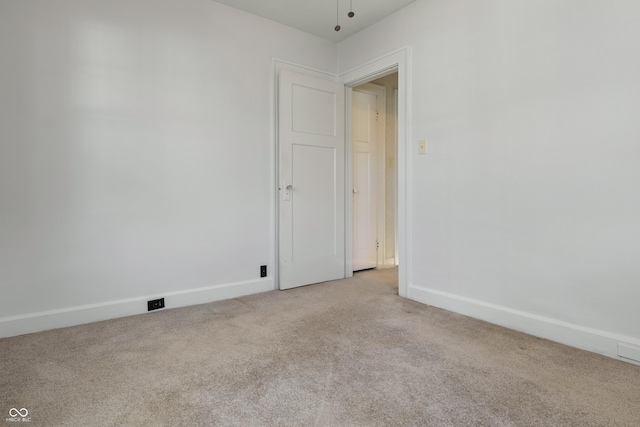 spare room featuring light colored carpet