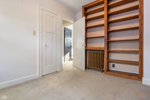 interior space featuring light colored carpet and radiator