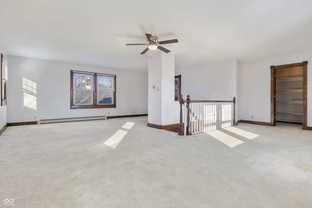 carpeted empty room featuring baseboard heating and ceiling fan