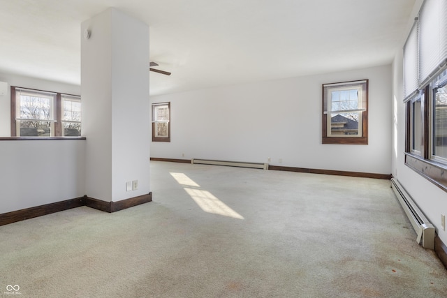 unfurnished room with a baseboard radiator, ceiling fan, and light colored carpet