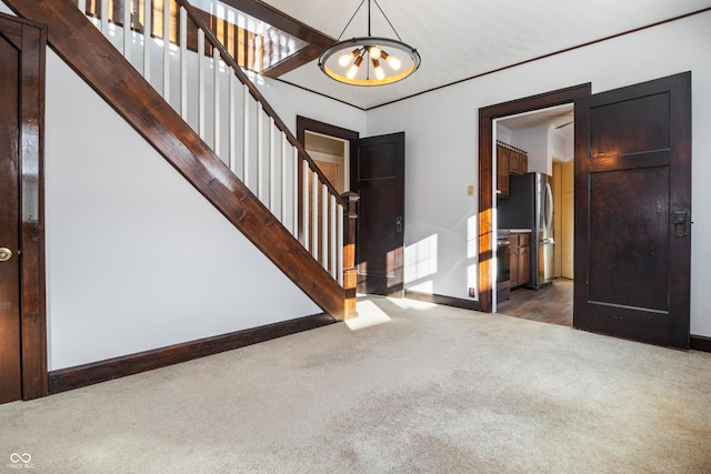 entrance foyer featuring dark colored carpet and a chandelier