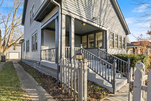 view of side of home featuring covered porch and an outdoor structure