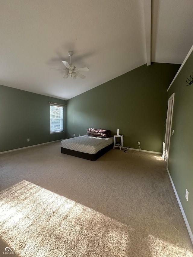 unfurnished bedroom featuring carpet flooring, vaulted ceiling with beams, baseboards, and ceiling fan