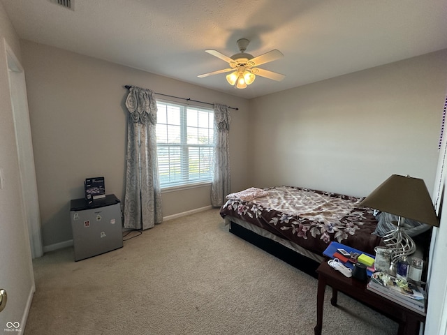 carpeted bedroom with ceiling fan and baseboards