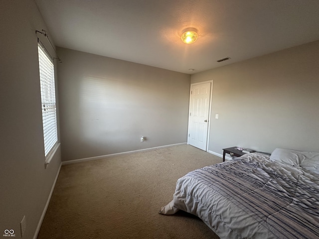 carpeted bedroom featuring visible vents and baseboards