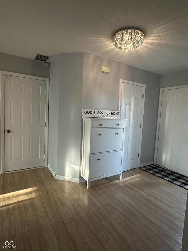 entrance foyer with visible vents, baseboards, and wood finished floors