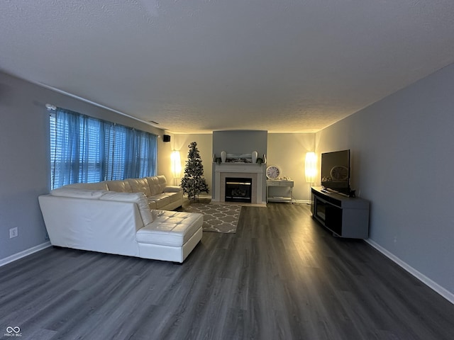 living room featuring baseboards, dark wood finished floors, and a fireplace