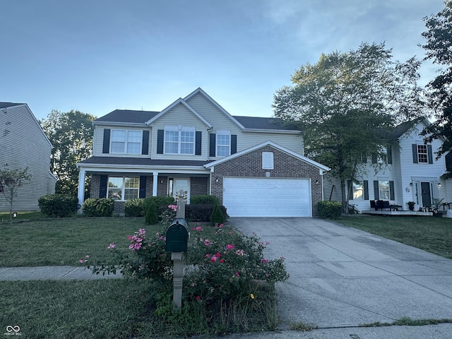 traditional-style home with a front yard, an attached garage, brick siding, and driveway