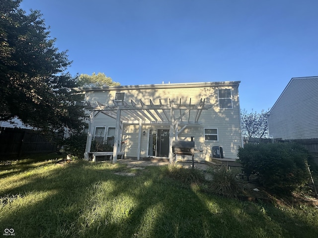 rear view of property with fence, a lawn, and a pergola