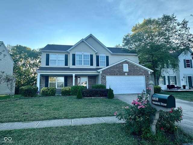 view of front facade with a garage, a front lawn, and covered porch