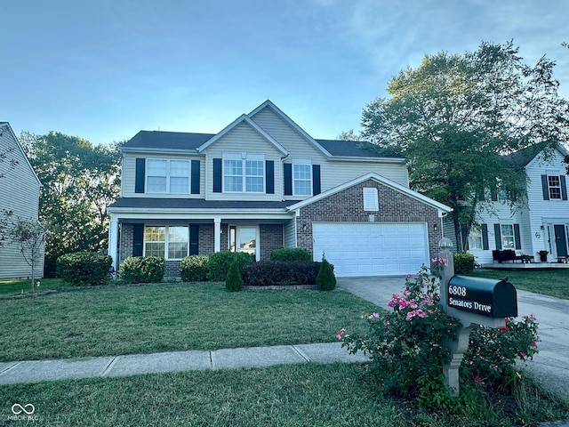 traditional-style home with driveway, brick siding, an attached garage, and a front lawn