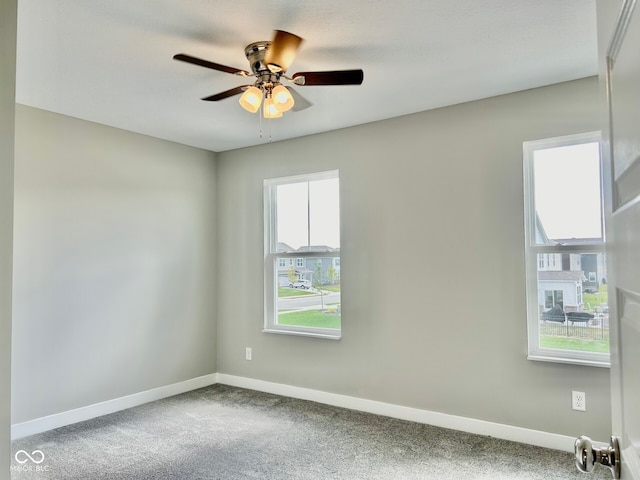 spare room featuring a wealth of natural light, ceiling fan, and carpet floors