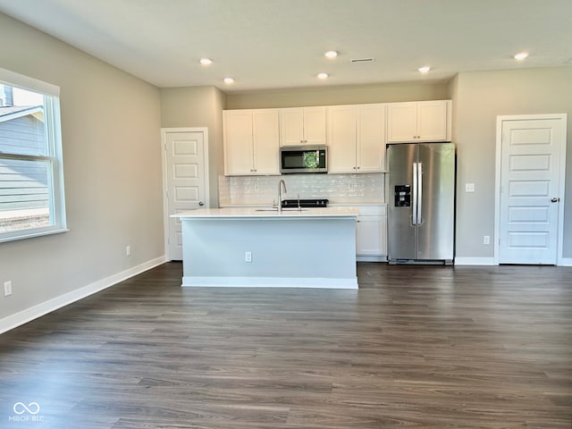 kitchen featuring dark wood-type flooring, white cabinetry, a healthy amount of sunlight, and stainless steel appliances