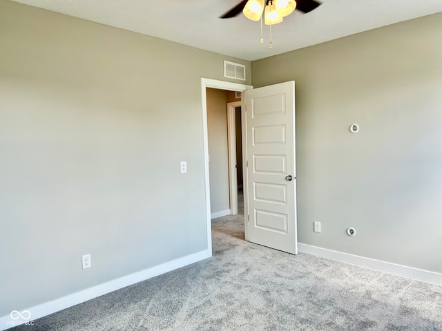 carpeted spare room with ceiling fan