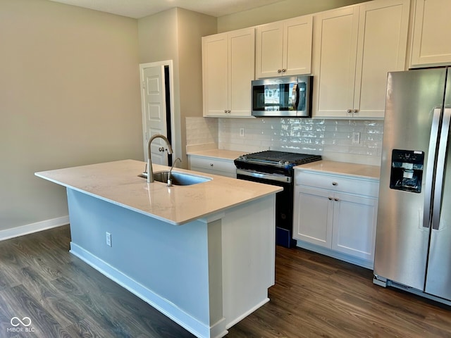 kitchen with stainless steel appliances, dark hardwood / wood-style flooring, white cabinetry, sink, and a kitchen island with sink