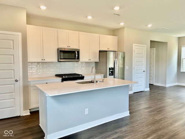 kitchen featuring an island with sink, sink, appliances with stainless steel finishes, and dark hardwood / wood-style flooring