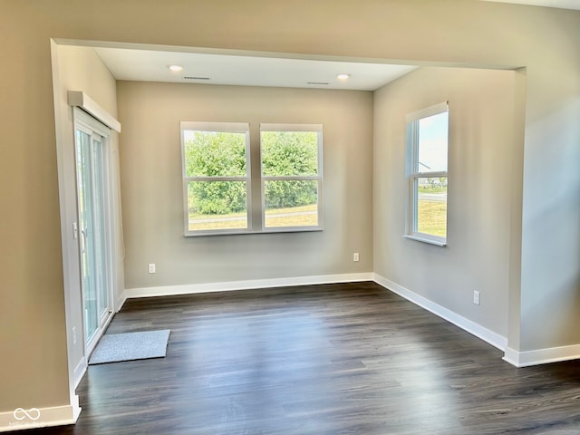 unfurnished room with dark wood-type flooring