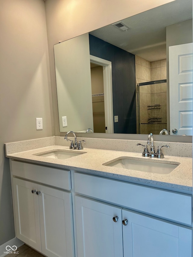 bathroom with walk in shower and vanity