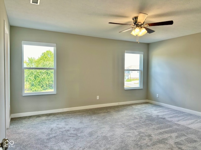 unfurnished room featuring a textured ceiling, ceiling fan, and carpet flooring