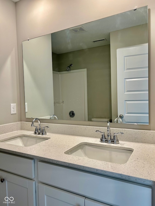 bathroom featuring vanity, toilet, and walk in shower