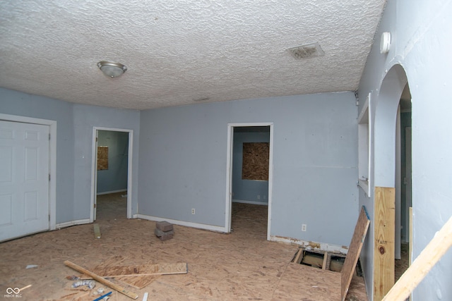 2363 N Gale St, Indianapolis, IN 46218 - empty room featuring arched walkways, a textured ceiling, a smoke detector, and baseboards