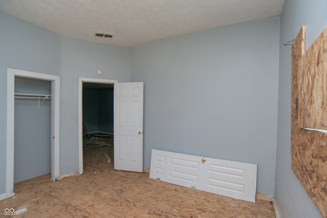 unfurnished bedroom featuring a textured ceiling and a closet