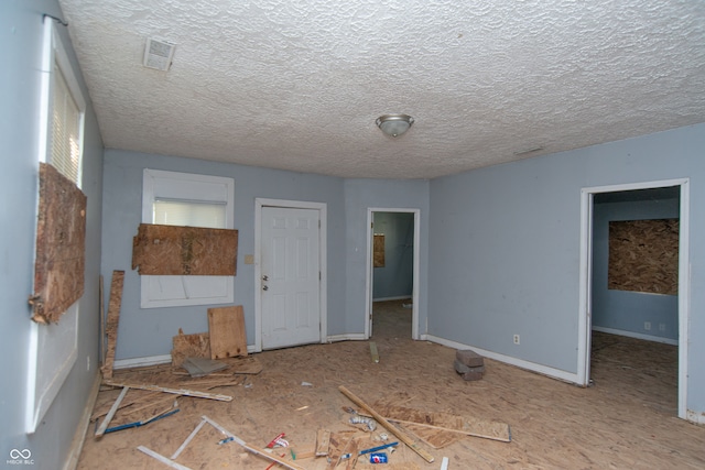 unfurnished bedroom with a spacious closet and a textured ceiling