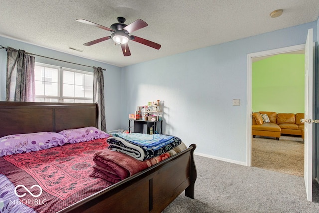 carpeted bedroom featuring ceiling fan and a textured ceiling