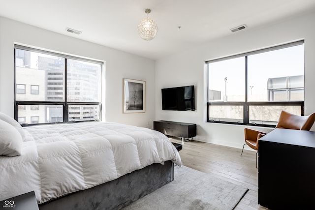 bedroom with light wood-type flooring and multiple windows