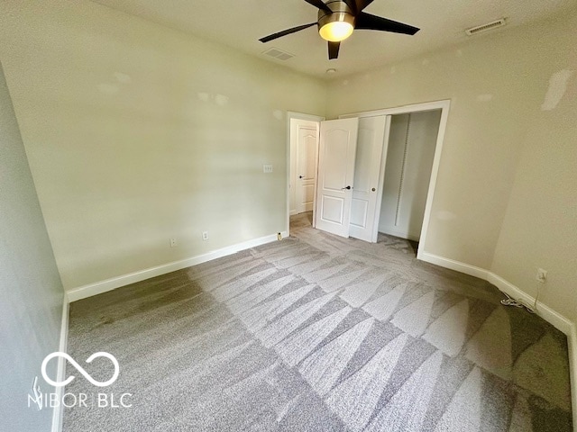 unfurnished bedroom with light colored carpet, ceiling fan, and a closet