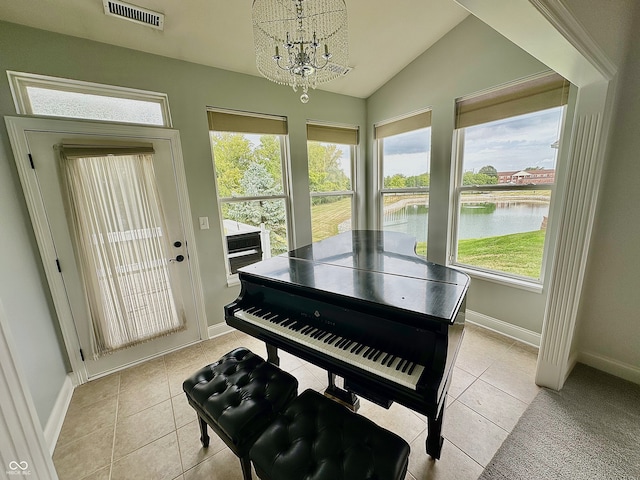 miscellaneous room featuring a healthy amount of sunlight, vaulted ceiling, an inviting chandelier, and a water view