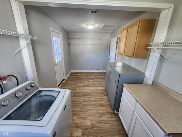 washroom with dark hardwood / wood-style floors, cabinets, and washer / clothes dryer