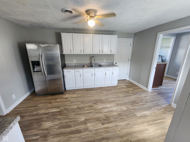 kitchen featuring stainless steel fridge with ice dispenser, sink, white cabinetry, hardwood / wood-style flooring, and ceiling fan