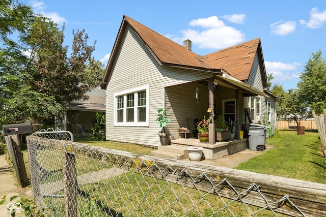 rear view of property featuring a lawn