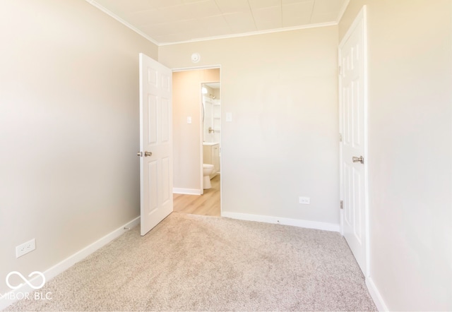 unfurnished bedroom featuring light colored carpet and crown molding