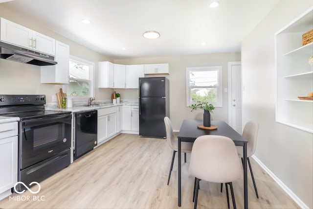 kitchen with black appliances, light hardwood / wood-style floors, and a healthy amount of sunlight