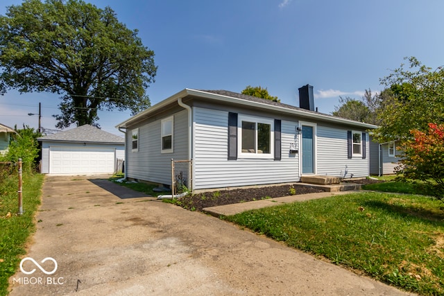 ranch-style home with a garage, a front yard, and an outbuilding