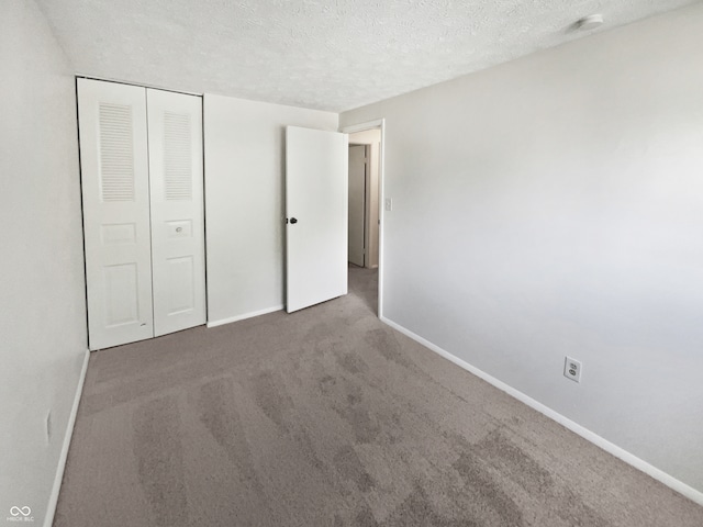 unfurnished bedroom with a closet, carpet, and a textured ceiling