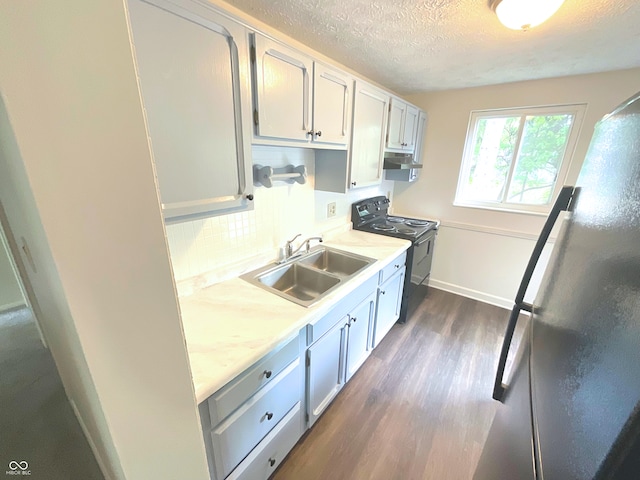 kitchen featuring stainless steel fridge, a textured ceiling, sink, dark hardwood / wood-style floors, and black / electric stove