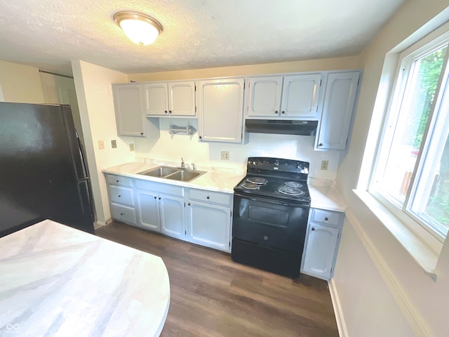 kitchen with a textured ceiling, black appliances, sink, dark wood-type flooring, and extractor fan