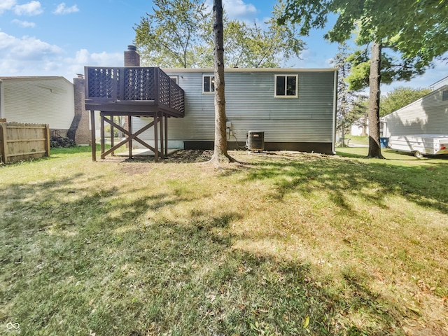 rear view of property featuring a lawn and central AC