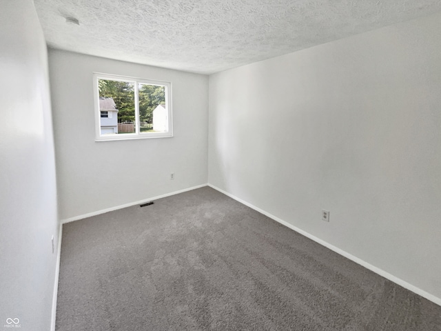 spare room featuring a textured ceiling and carpet floors