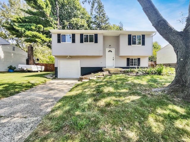 raised ranch featuring a garage and a front lawn